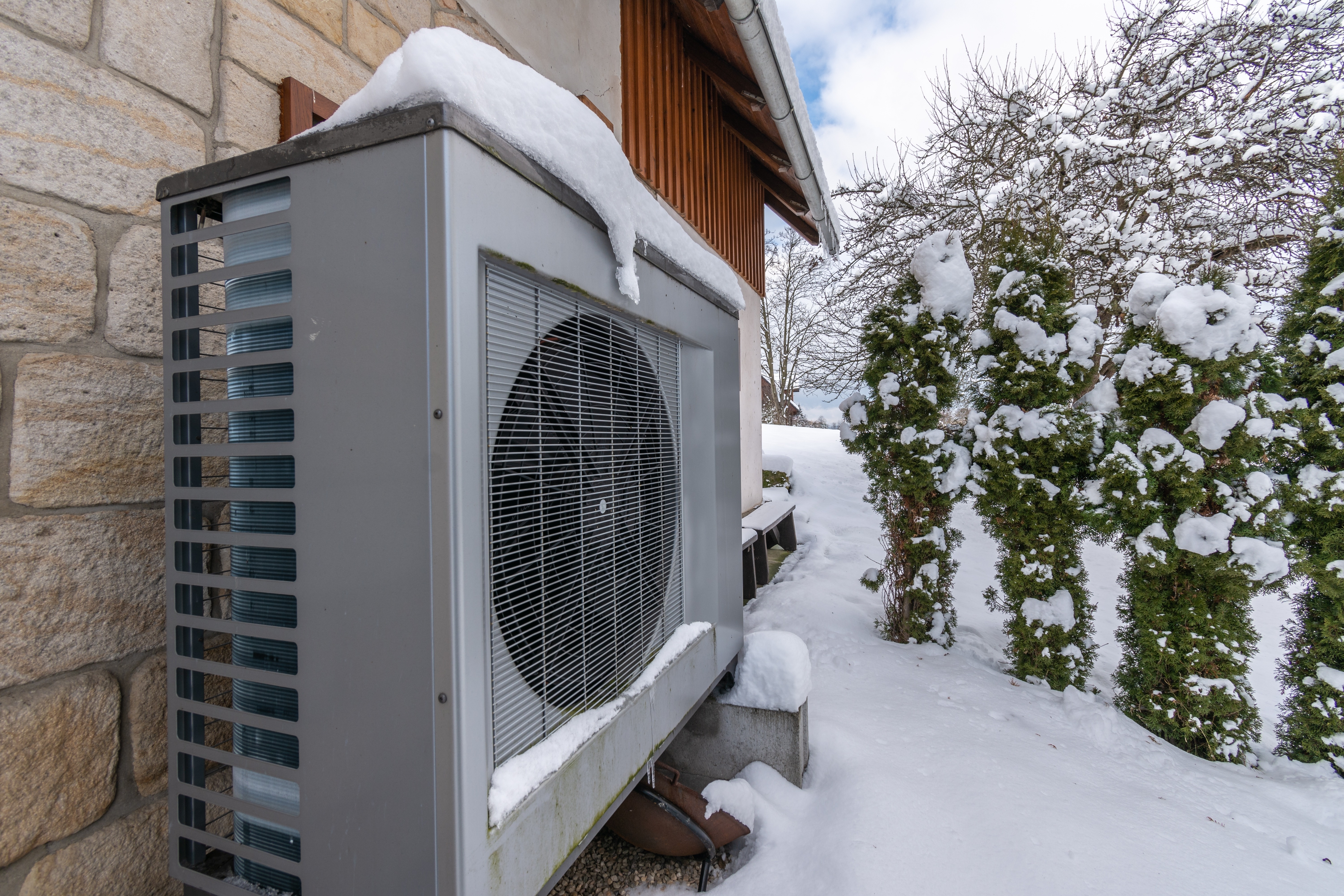 Heat pump on the side of a house in winter